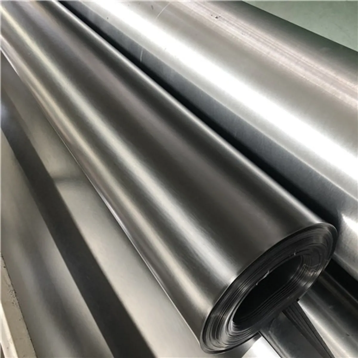 Rolls of smooth black HDPE geomembrane liner in the SIGMA factory